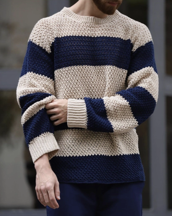 a man wearing a knit sweater with bold blue and white stripes