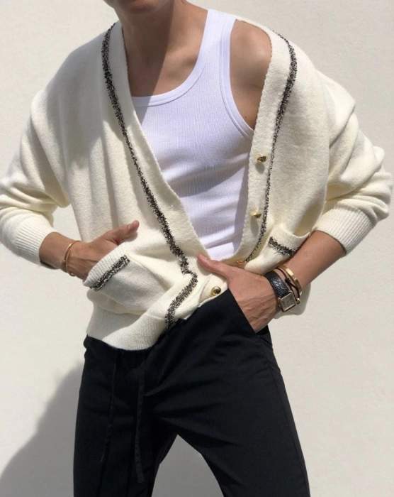 a young man wearing a whit kni cardigan