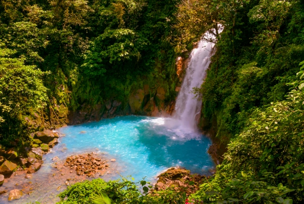 romantic honeymoon in costa rica. a waterfall surrounded by a forrest