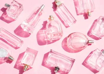 many perfume flacons on a pink background