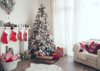 a living room a modern white christmas tree next to a chimney and a white sofa as a christmas decor idea