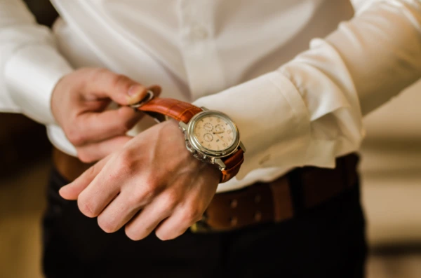 a man puts on a classic watch