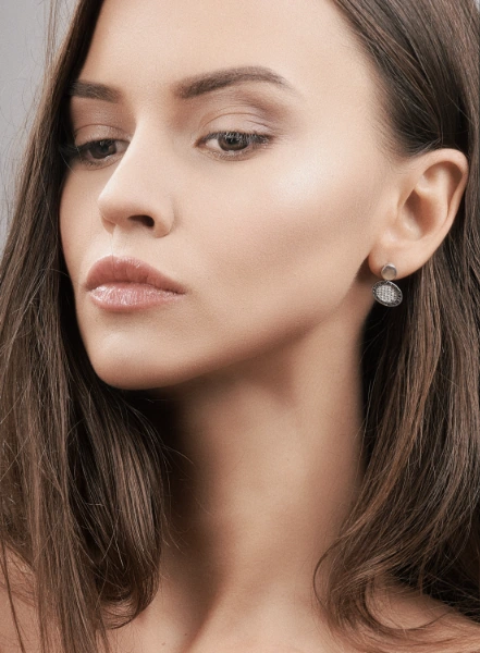 a young dark blone woman wearing silver filigree earrings
