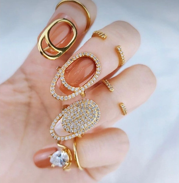 a hand with sparkling diamond nail rings