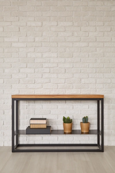 a simple black side board in front of a white brick wall