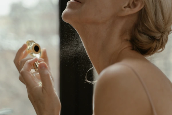 a blonde woman puts on perfume