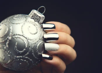 winter nails style: an silver ornament in a hand with matt and chrome nail polish