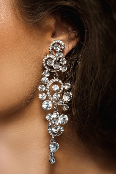 a woman wearing xxl diamond earrings as winter jewelry