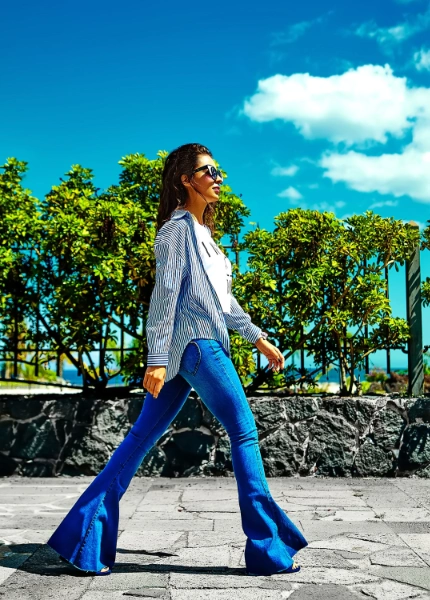 a woman wearing a flattering topo and flare jeans
