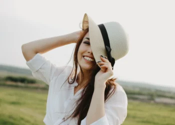 a young and happy brunette woman is wearing a white hat