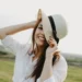 a young and happy brunette woman is wearing a white hat